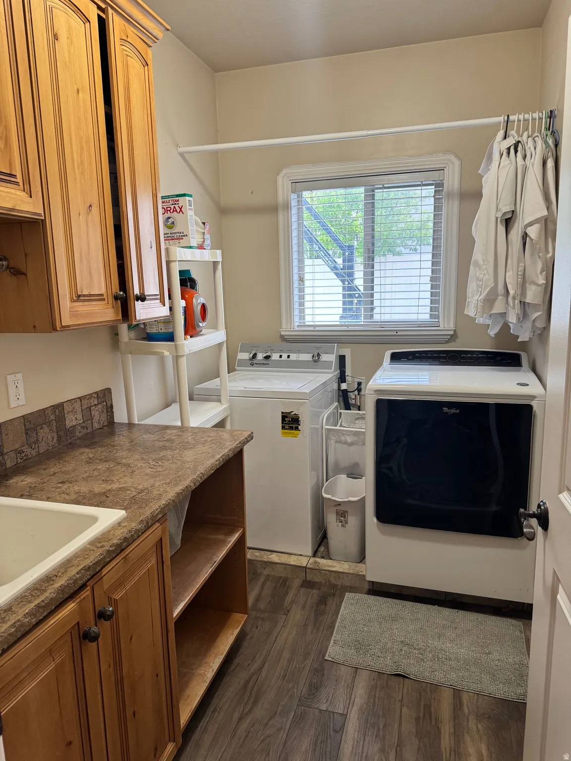 Laundry room with washer and clothes dryer, dark wood-style flooring, and cabinet space