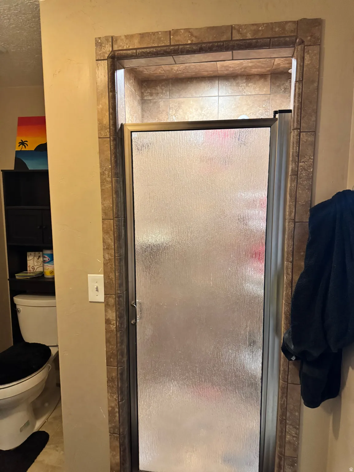 Bathroom with a stall shower and a textured ceiling
