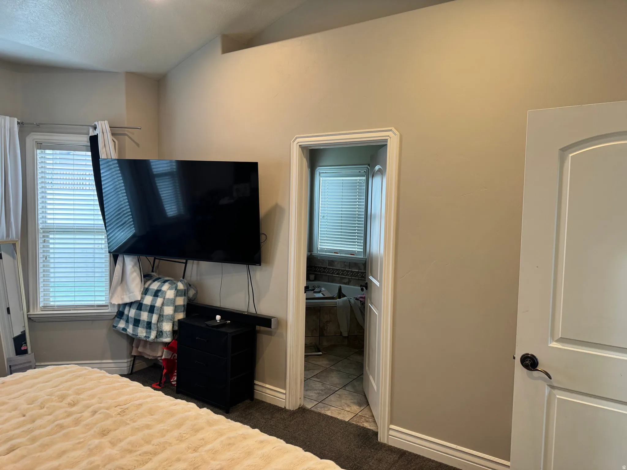 Bedroom with light colored carpet and connected bathroom