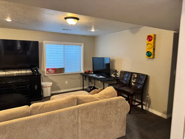 Living area with a textured ceiling and carpet floors