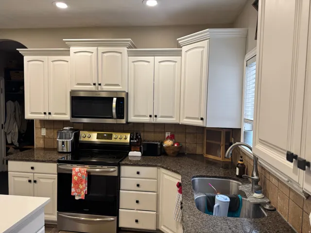 Kitchen featuring stainless steel appliances, tasteful backsplash, white cabinets, and recessed lighting