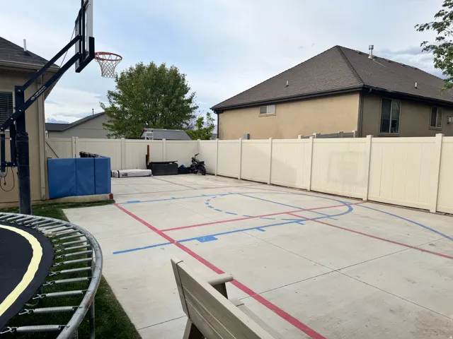 View of sport court with a fenced backyard and a trampoline
