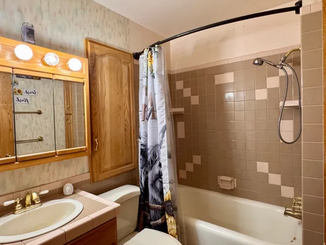 Full bath with vanity and shower / bath combo with shower curtain