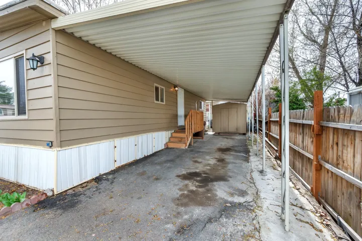 View of parking with a storage shed and a carport