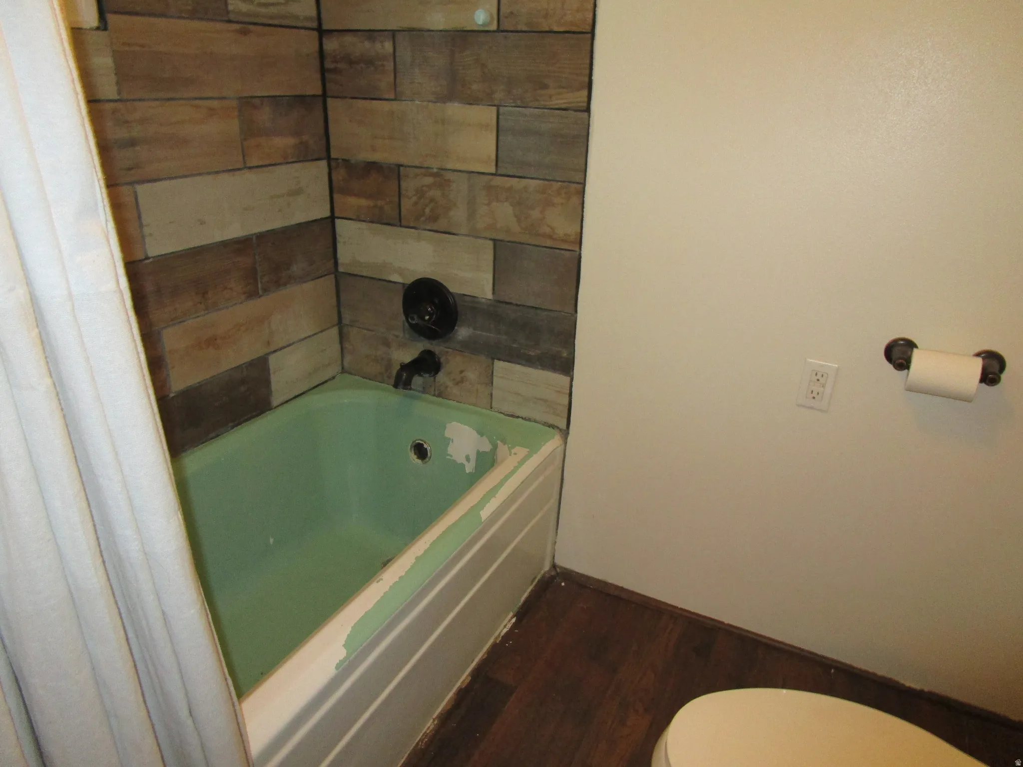 Bathroom with toilet and dark wood-type flooring
