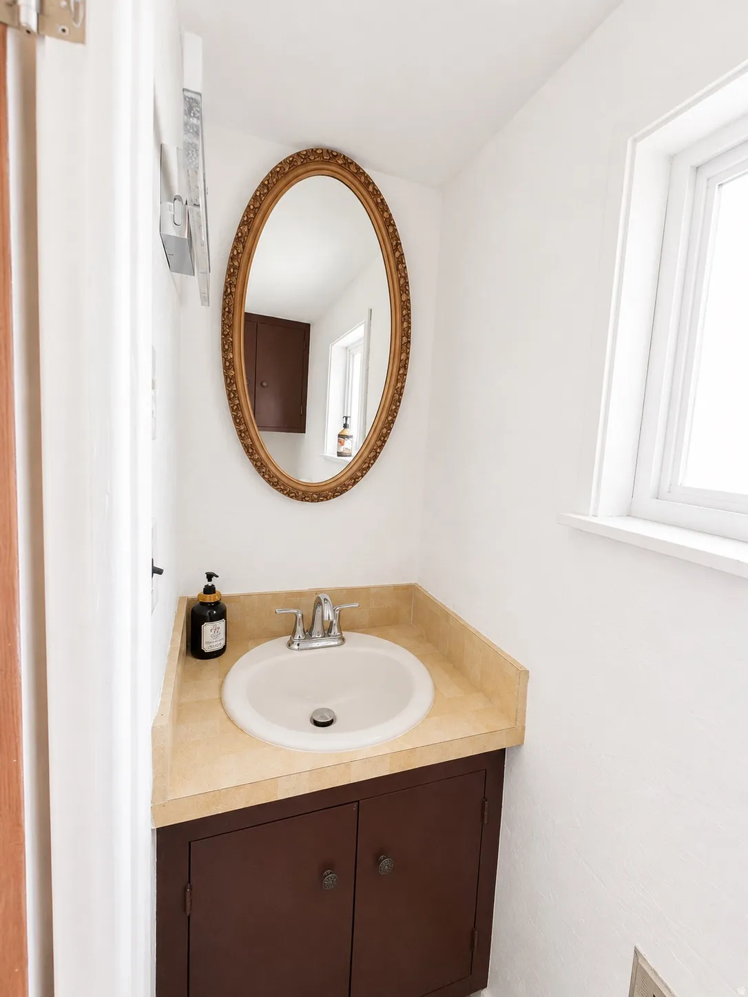 Compact bathroom vanity featuring a light-colored countertop, integrated sink, and dark wood cabinetry