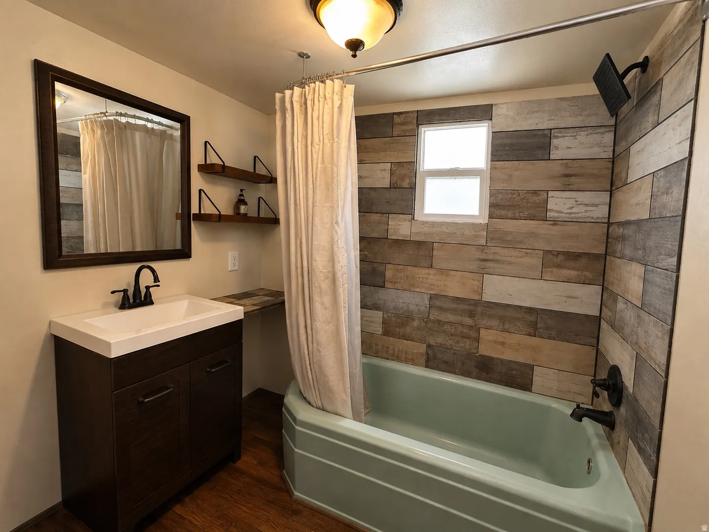 Bathroom featuring a built-in bathtub with a wall-mounted shower fixture, wood-finish wall paneling, and a framed window