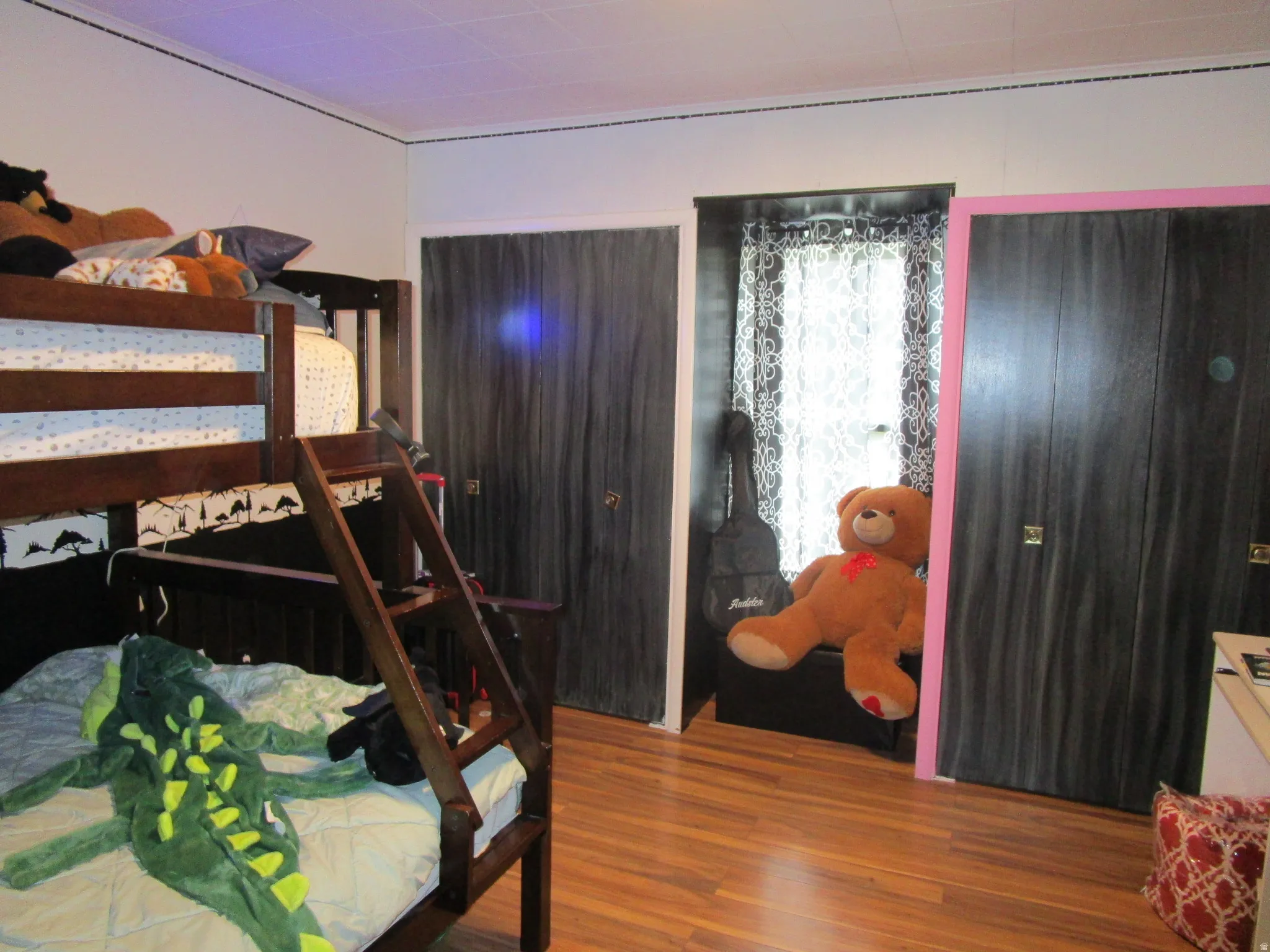 Bedroom with wood finished floors and crown molding