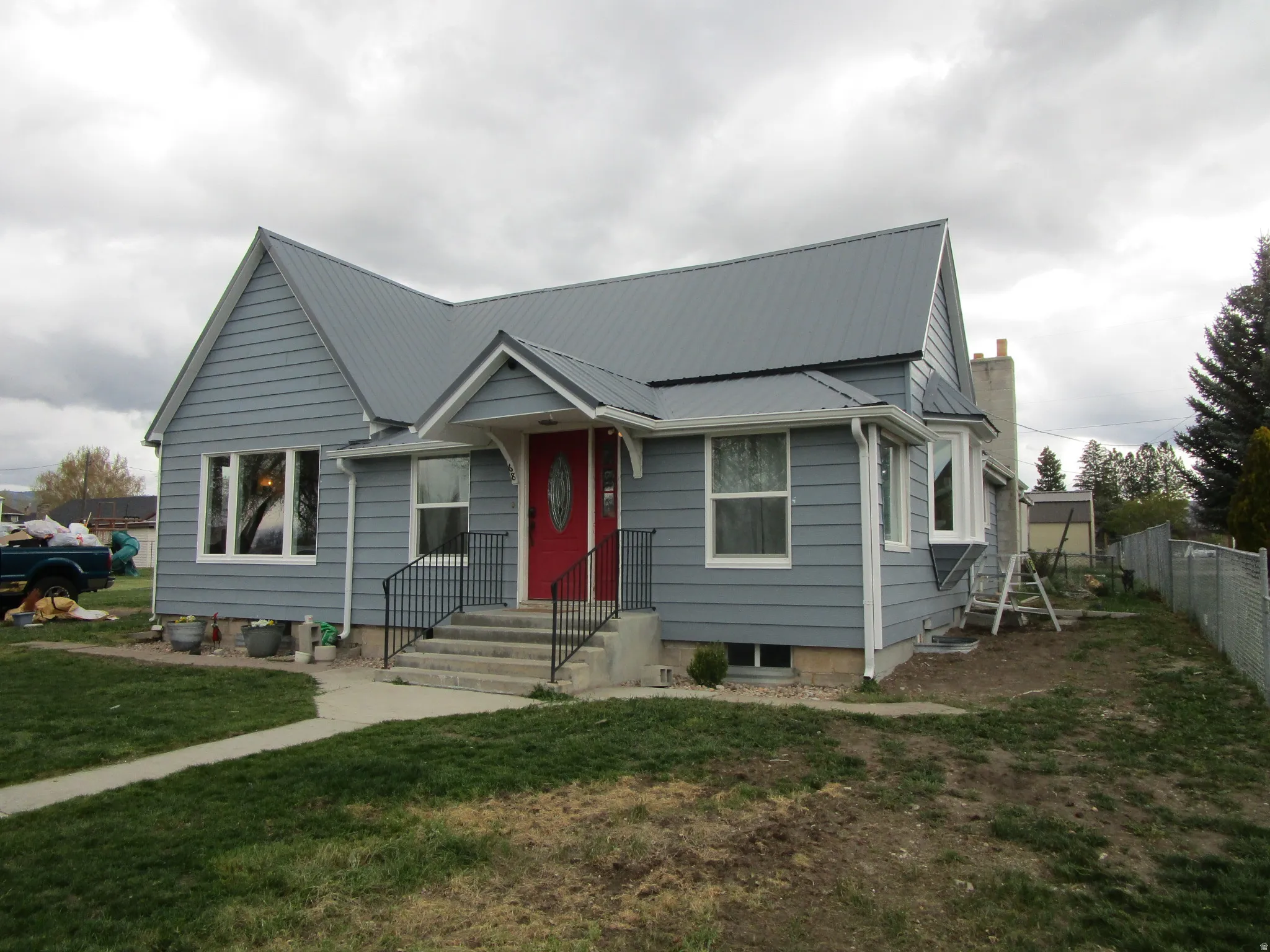 Bungalow-style house with a metal roof and large lot.