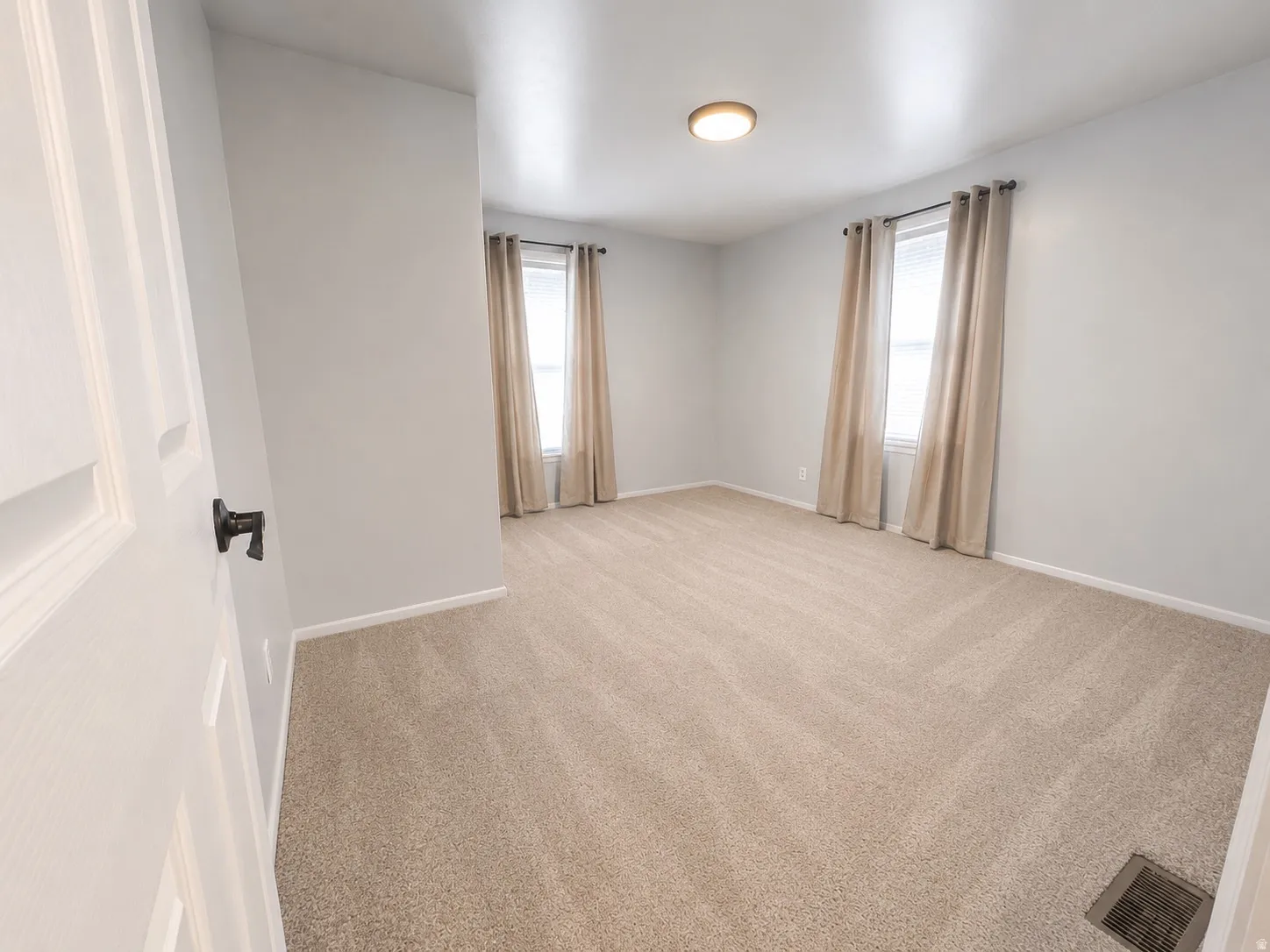 Carpeted room with light neutral wall paint and white trim