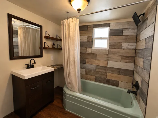 Bathroom featuring a built-in bathtub with a wall-mounted shower fixture, wood-finish wall paneling, and a framed window
