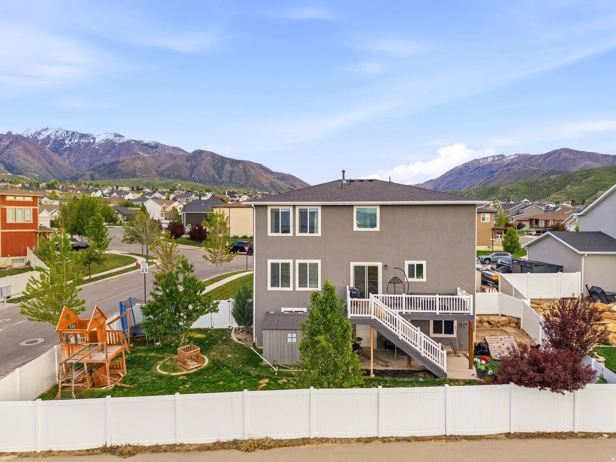 Back of property featuring a residential view, a fenced backyard, a mountain view, and stucco siding