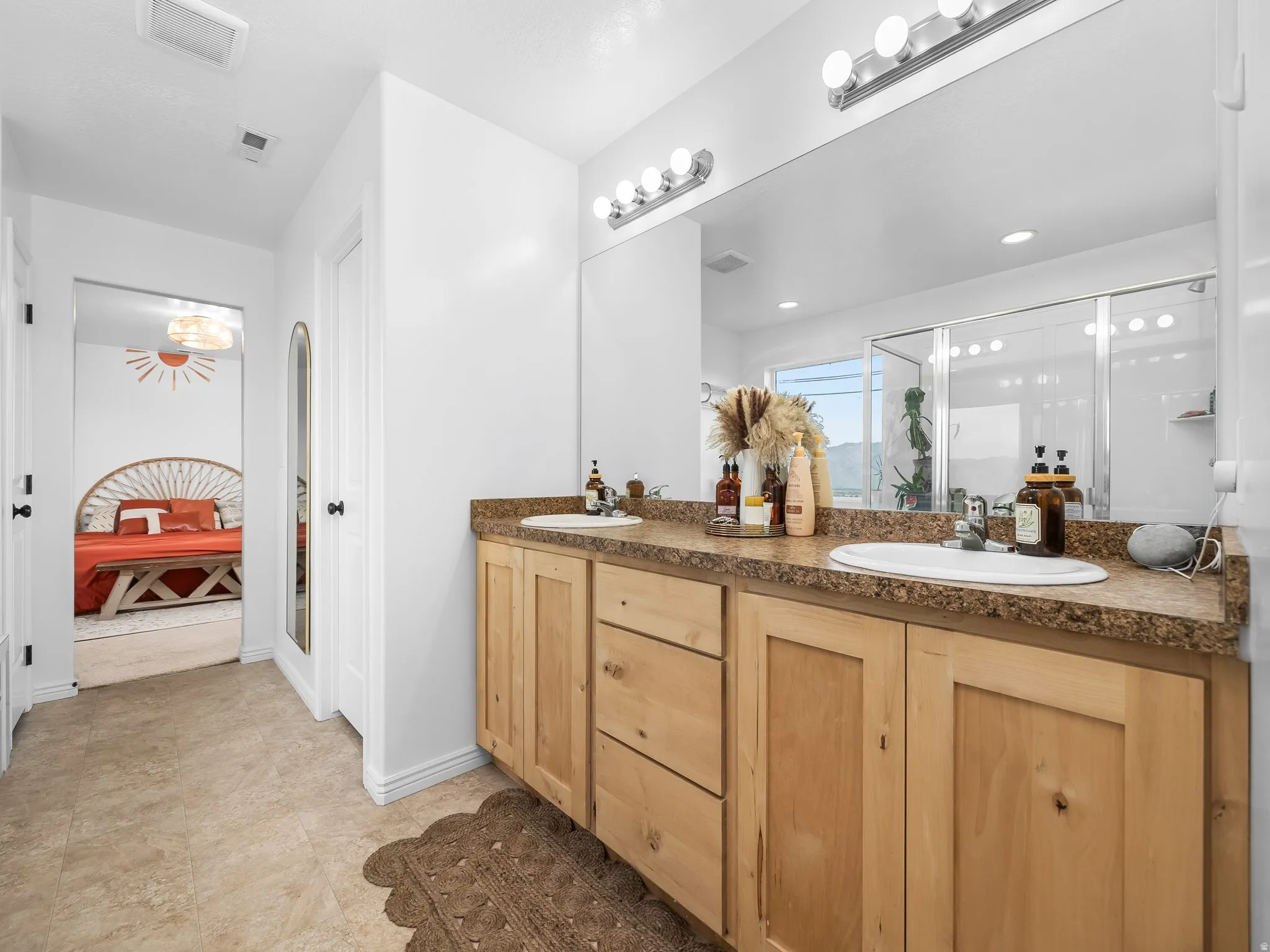 Full bath with double vanity and a stall shower