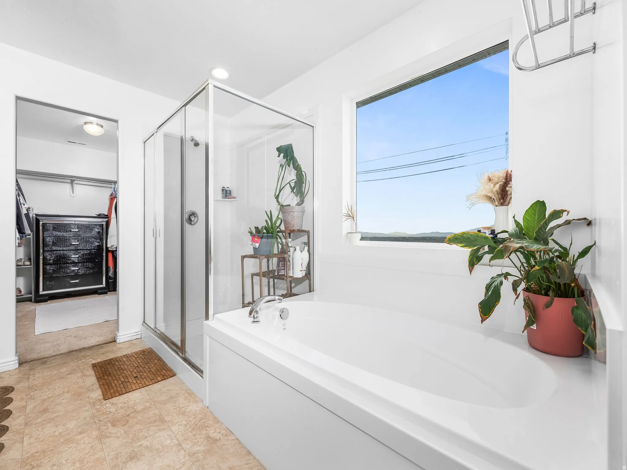 Full bathroom with a bath, a stall shower, a spacious closet, and recessed lighting