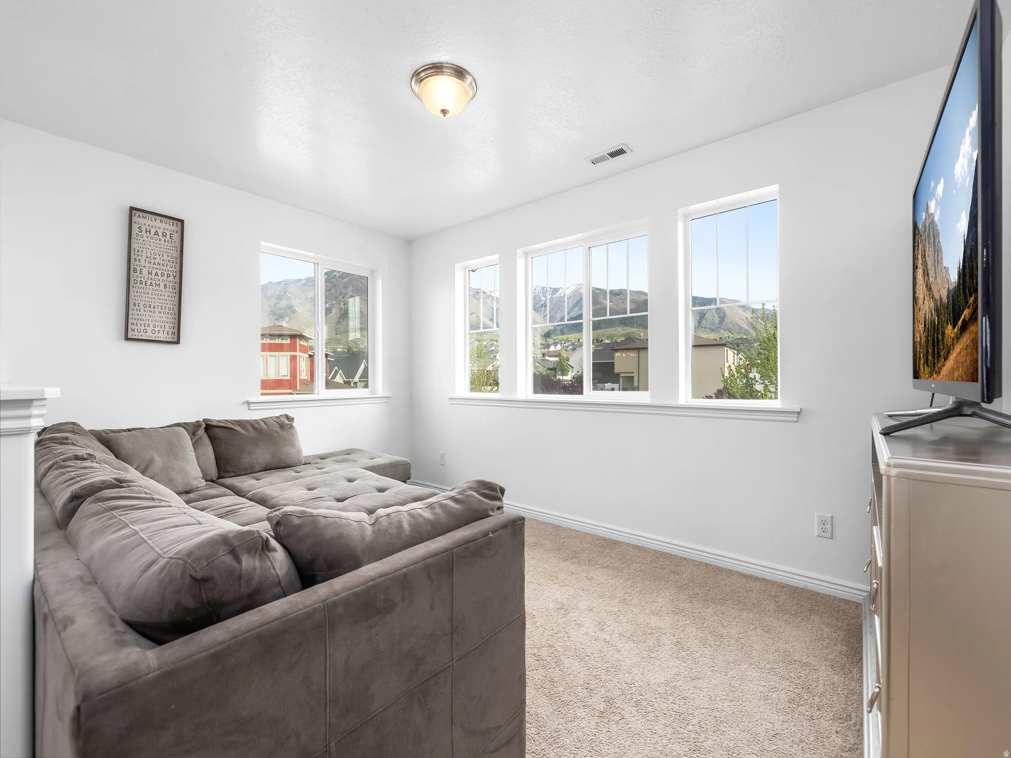 Living area with baseboards and light carpet