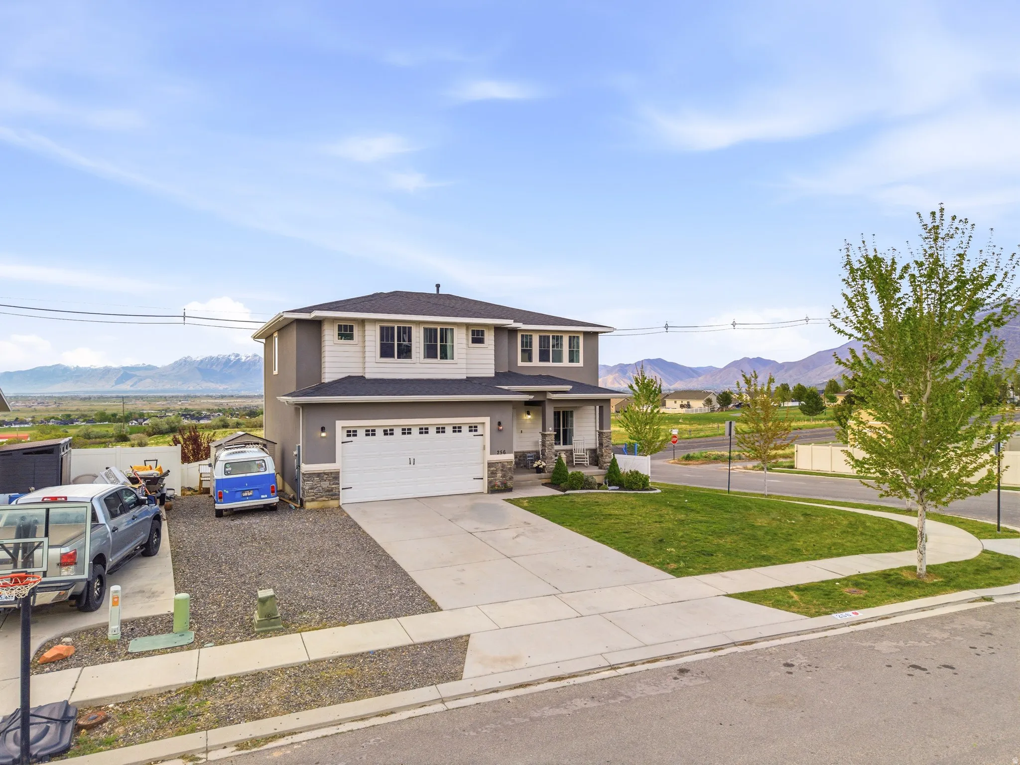 View of front of home featuring a mountain view, covered porch, concrete driveway, and stone siding