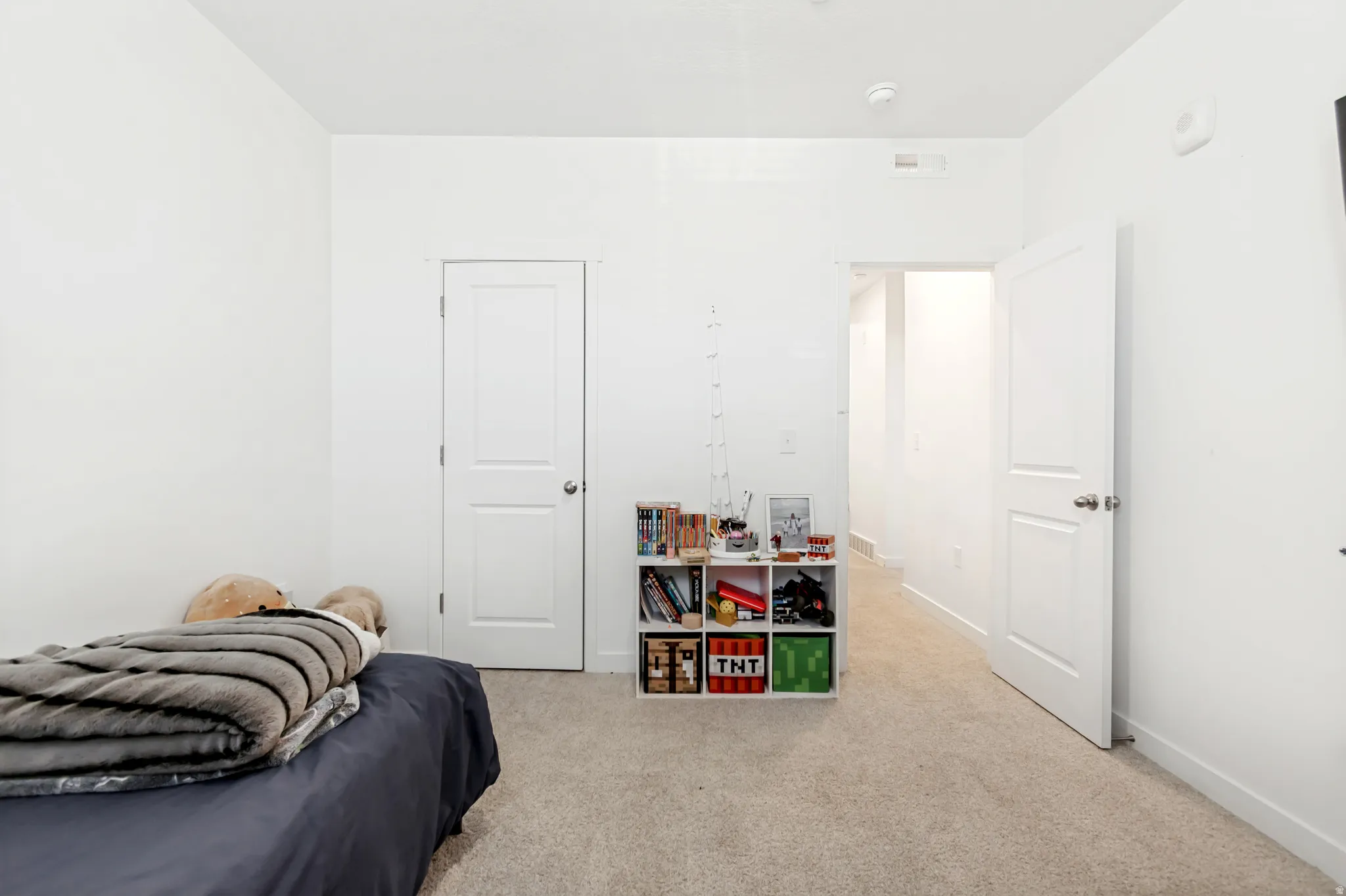 Bedroom featuring light colored carpet and baseboards