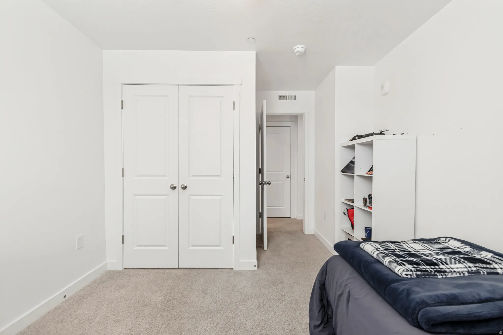 Bedroom with light carpet and a closet