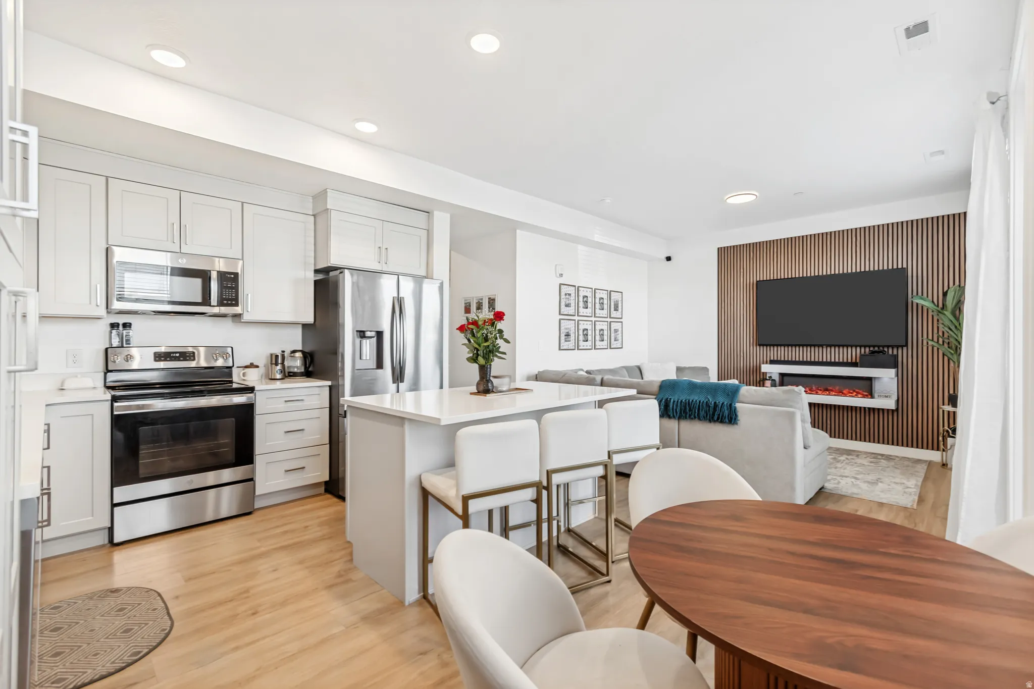 Kitchen with stainless steel appliances, open floor plan, light wood-style floors, a breakfast bar, and a kitchen island