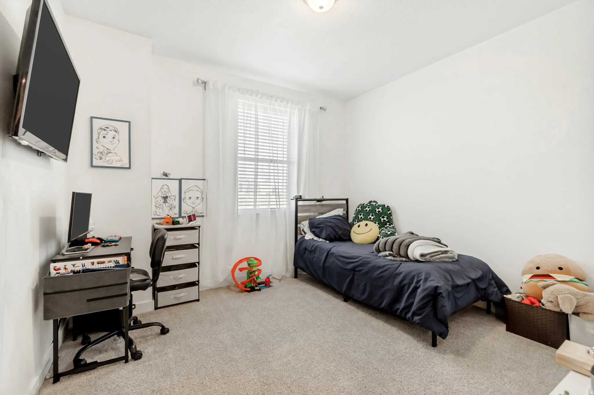 Bedroom with light colored carpet and an office area
