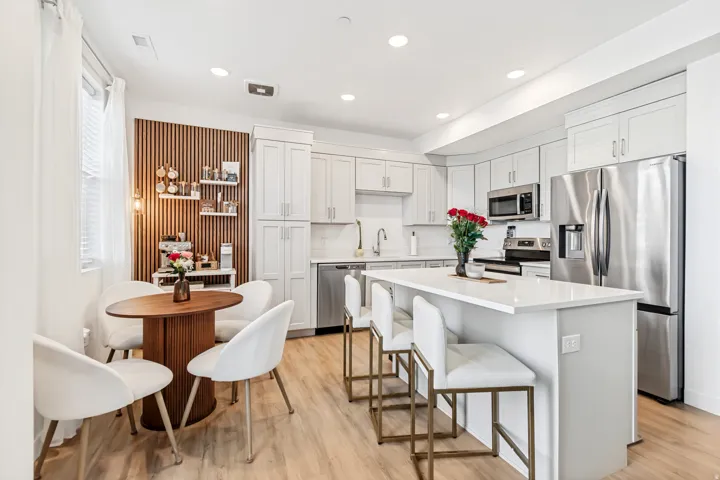 Kitchen with stainless steel appliances, a kitchen island, light wood-style floors, a kitchen breakfast bar, and recessed lighting