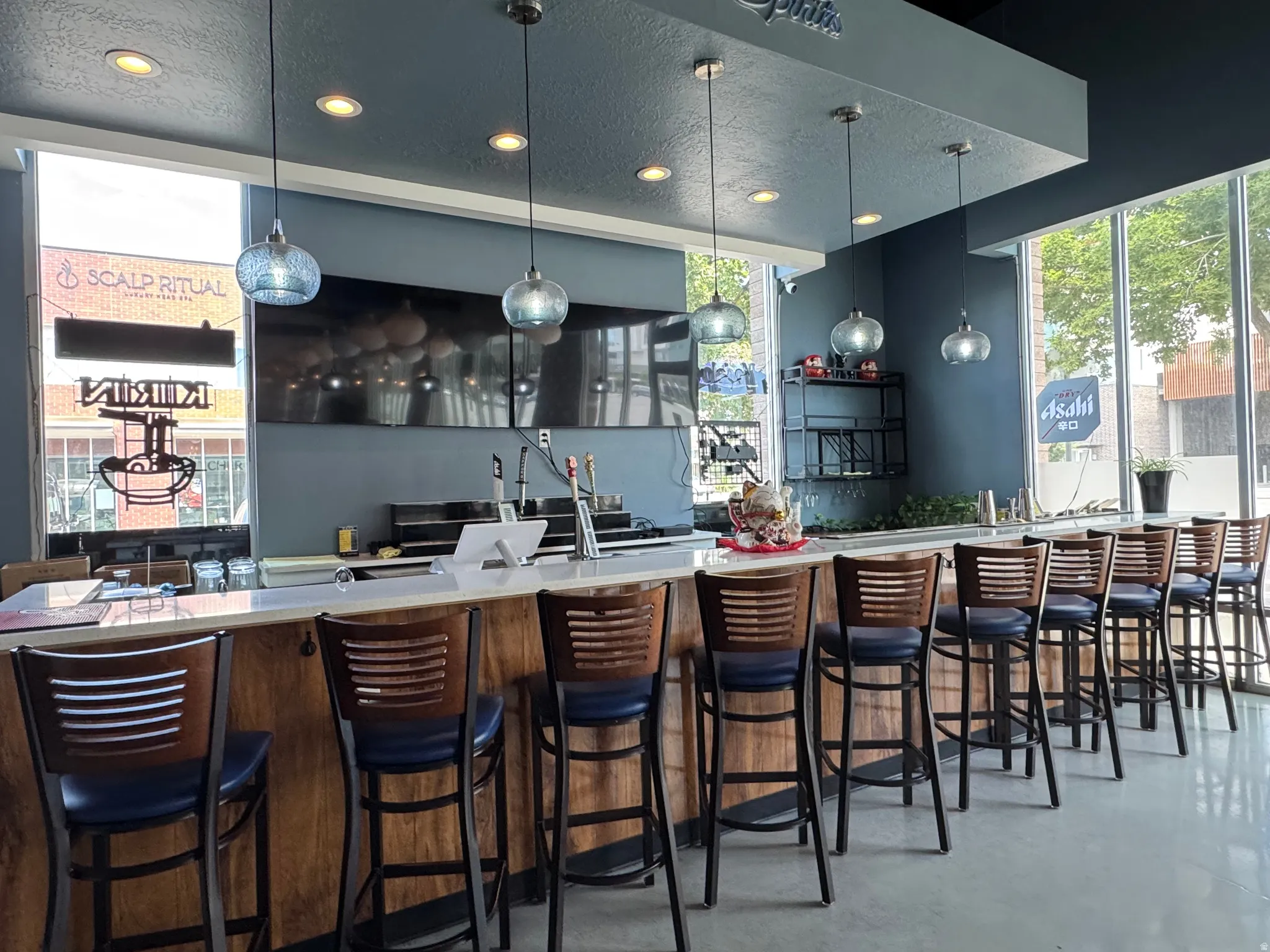 Bar with a textured ceiling, pendant lighting, and light stone counters