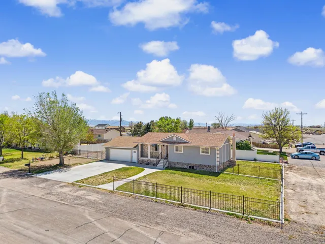 Single story home with a fenced front yard, concrete driveway, a garage, and a residential view