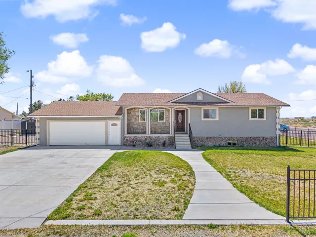 Ranch-style home featuring driveway, an attached garage, stucco siding, and stone siding