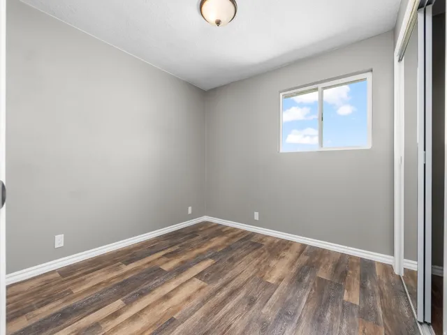 Unfurnished bedroom featuring dark wood-style floors and a closet