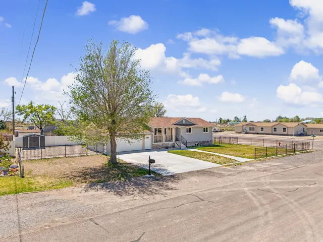 Ranch-style home featuring a fenced front yard, concrete driveway, and a residential view