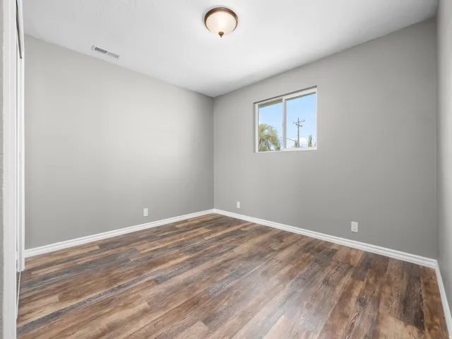 Unfurnished room with dark wood finished floors and baseboards