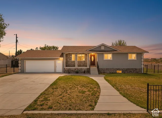 Single-story exterior with a two-car garage, stone facade accents, and a front pathway