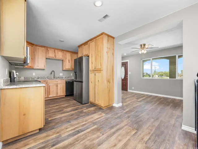 Kitchen featuring light wood finish cabinets, dark wood-style floors, stainless steel appliances, recessed lighting, and ceiling fan
