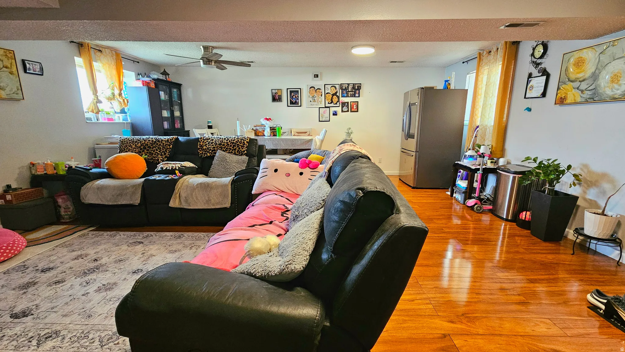 Living area featuring light wood-type flooring and a ceiling fan