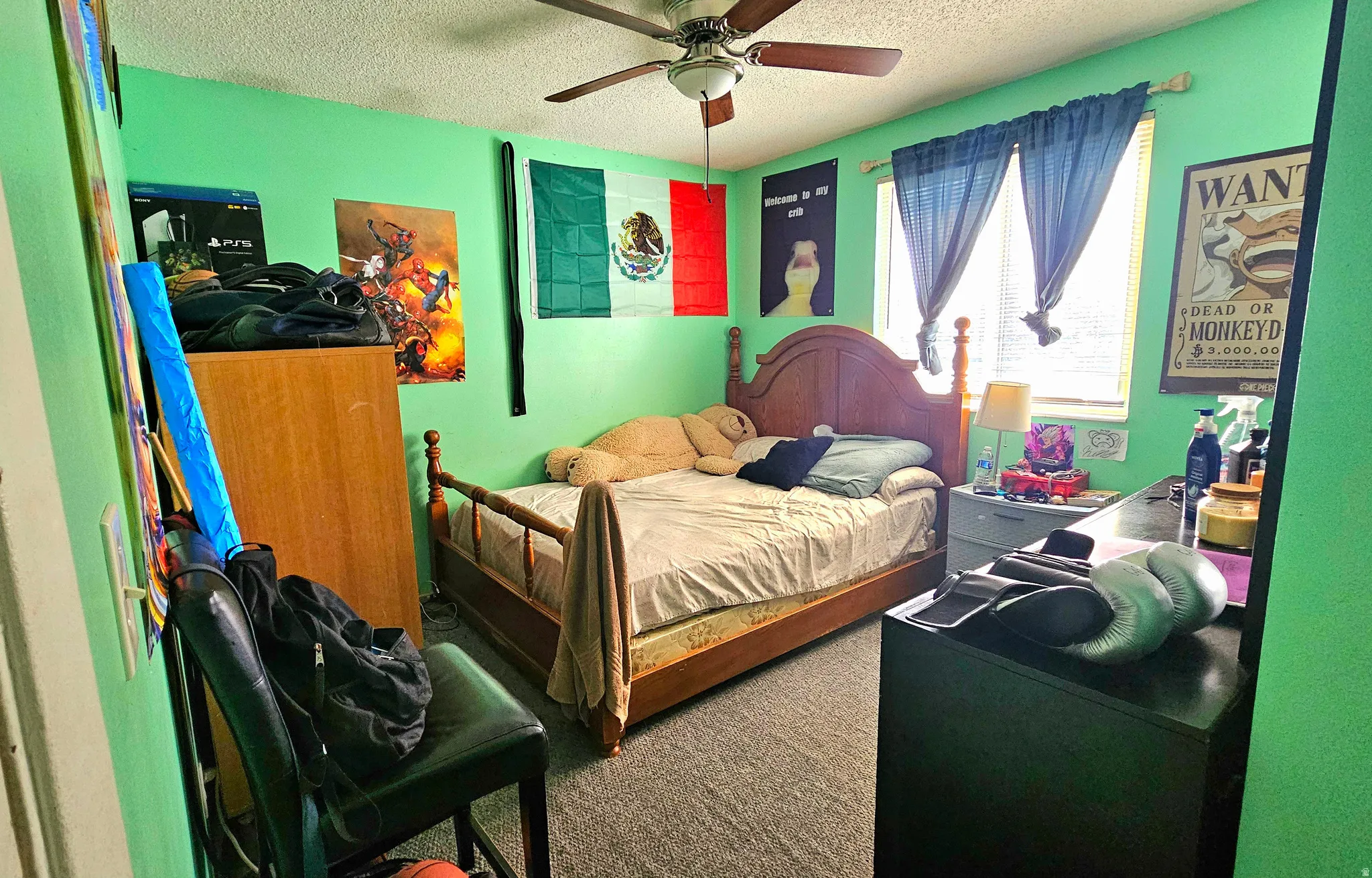 Carpeted bedroom featuring a textured ceiling and ceiling fan