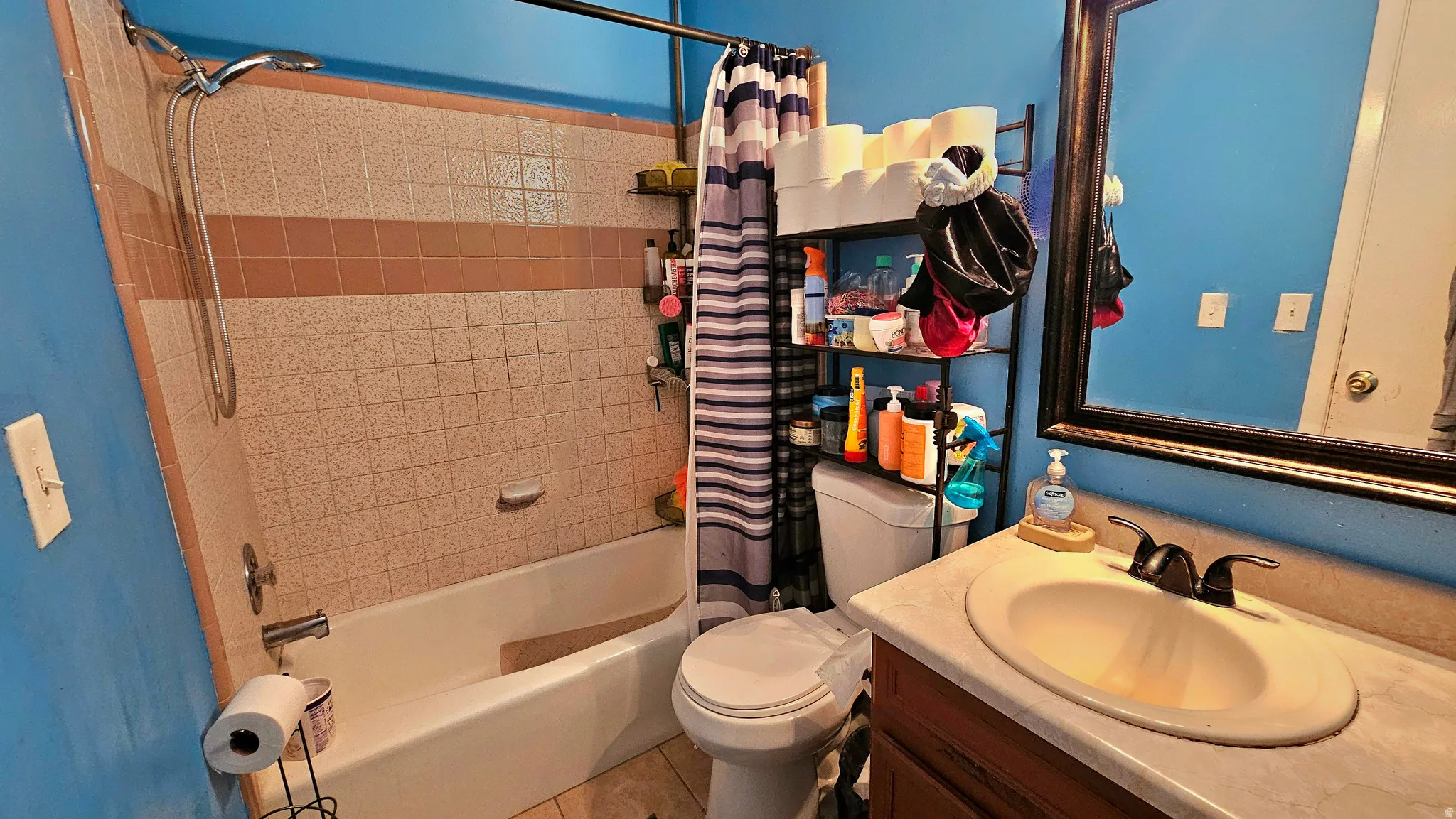 Full bath with vanity, shower / bath combination with curtain, and light tile patterned floors