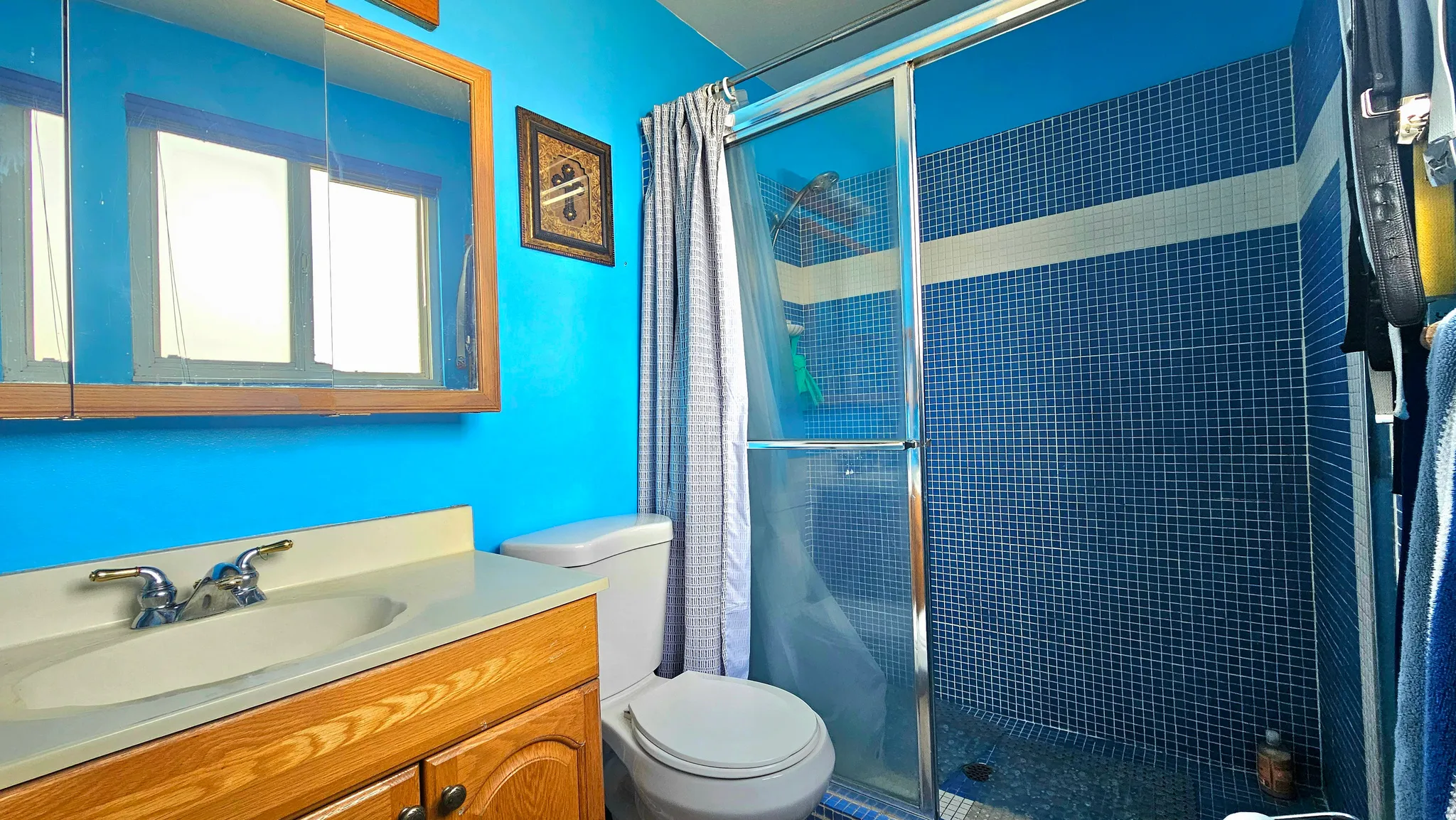 Full bath featuring a stall shower and vanity