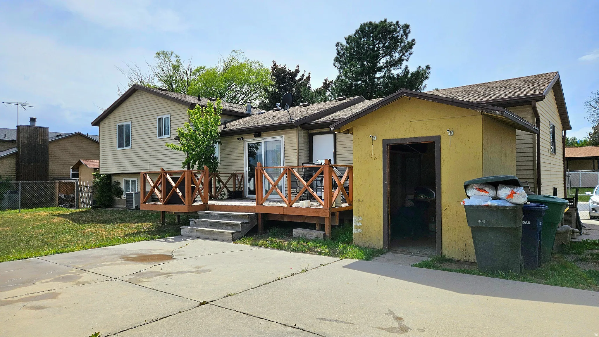 View of front of home with a deck and roof with shingles