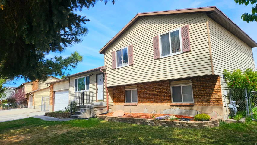Tri-level home with brick siding and a garage