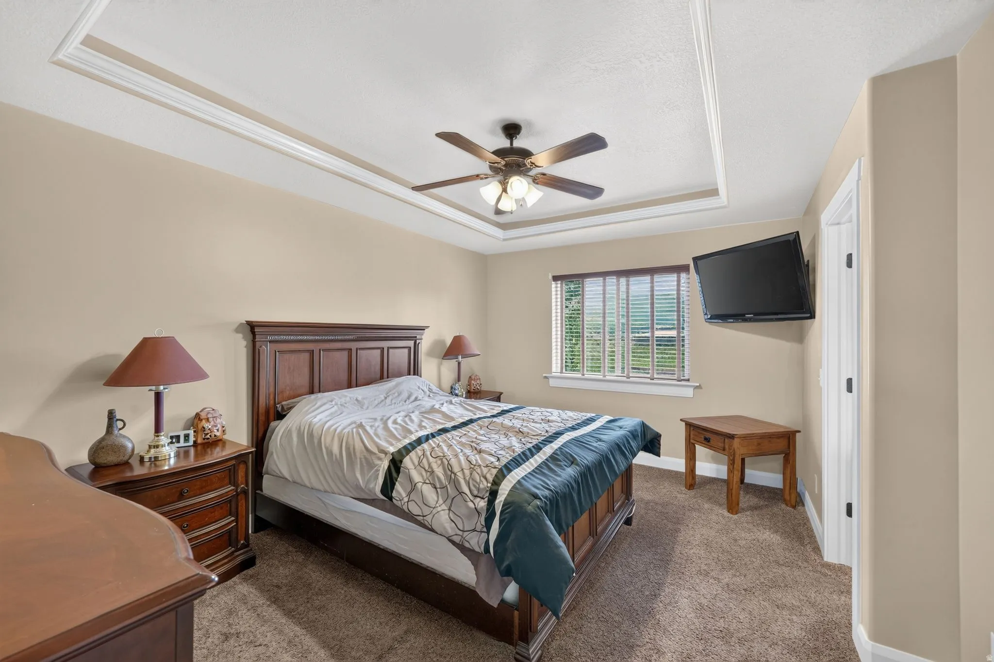 Recessed ceiling with layered crown molding and a ceiling fan with integrated lighting