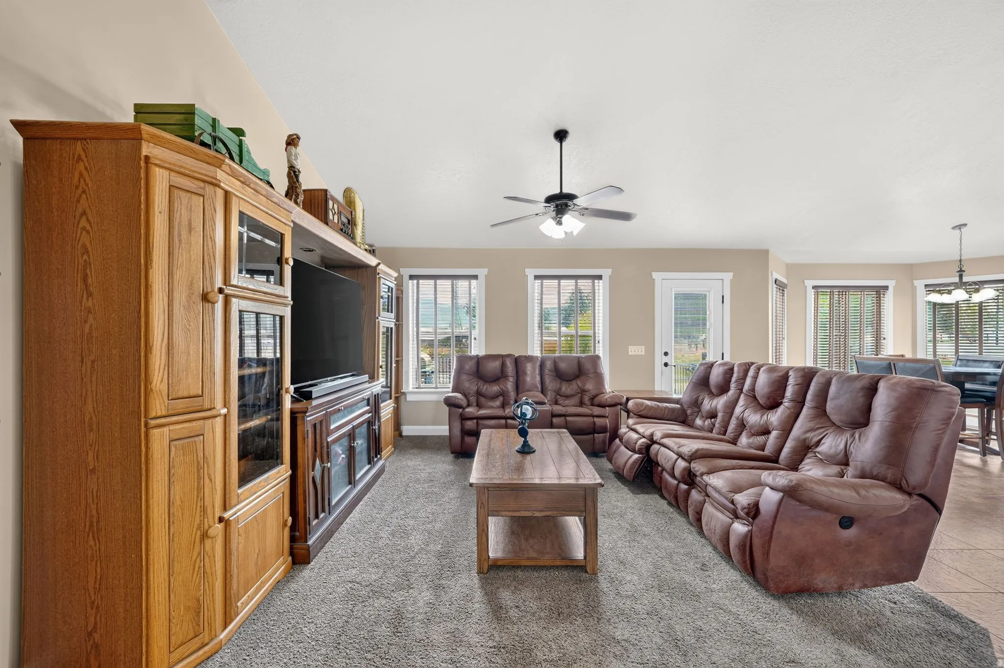 Spacious living area featuring neutral-toned walls and plush grey carpeting
