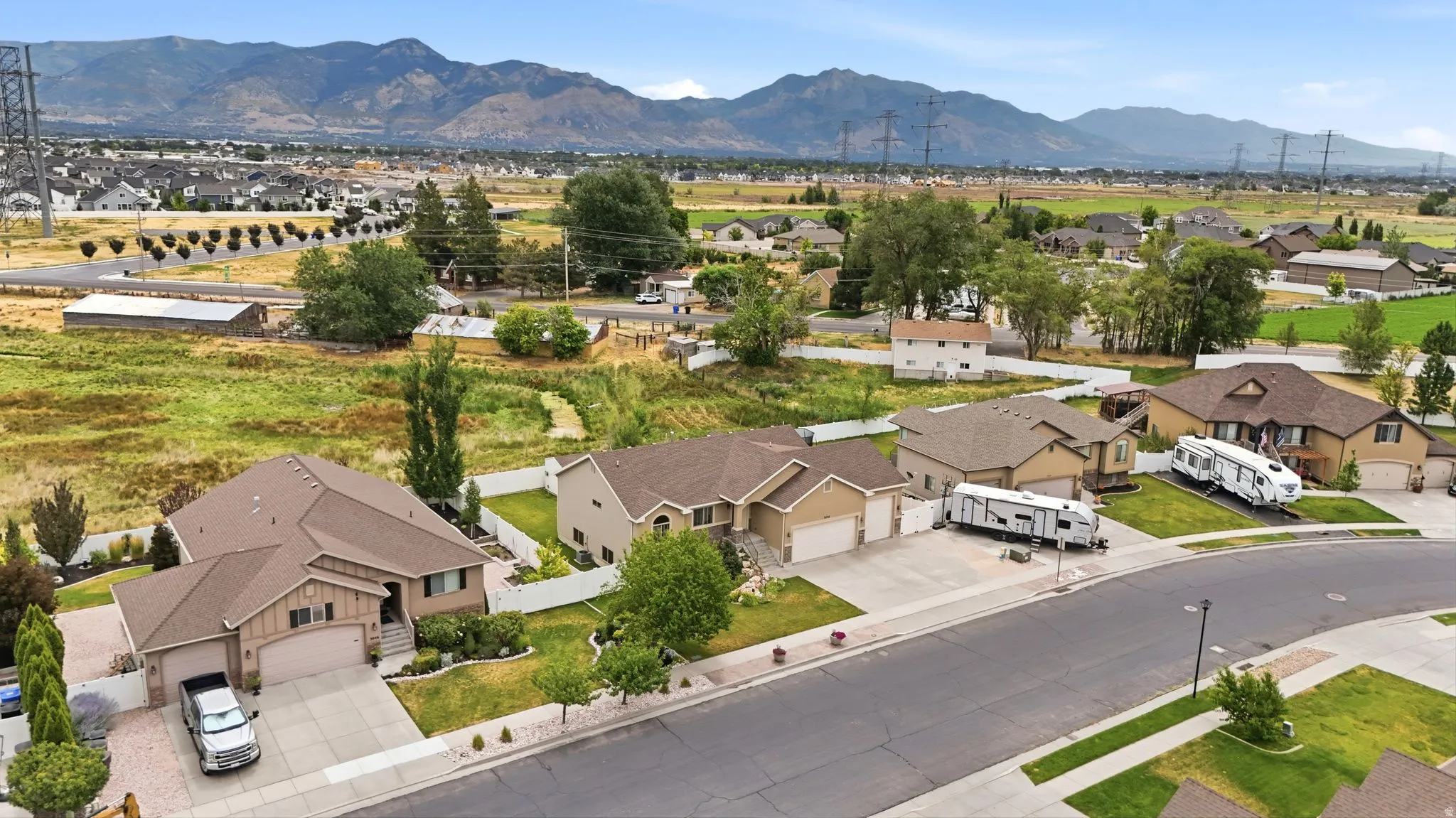 Expansive residential street featuring multiple properties with attached garages and paved driveways