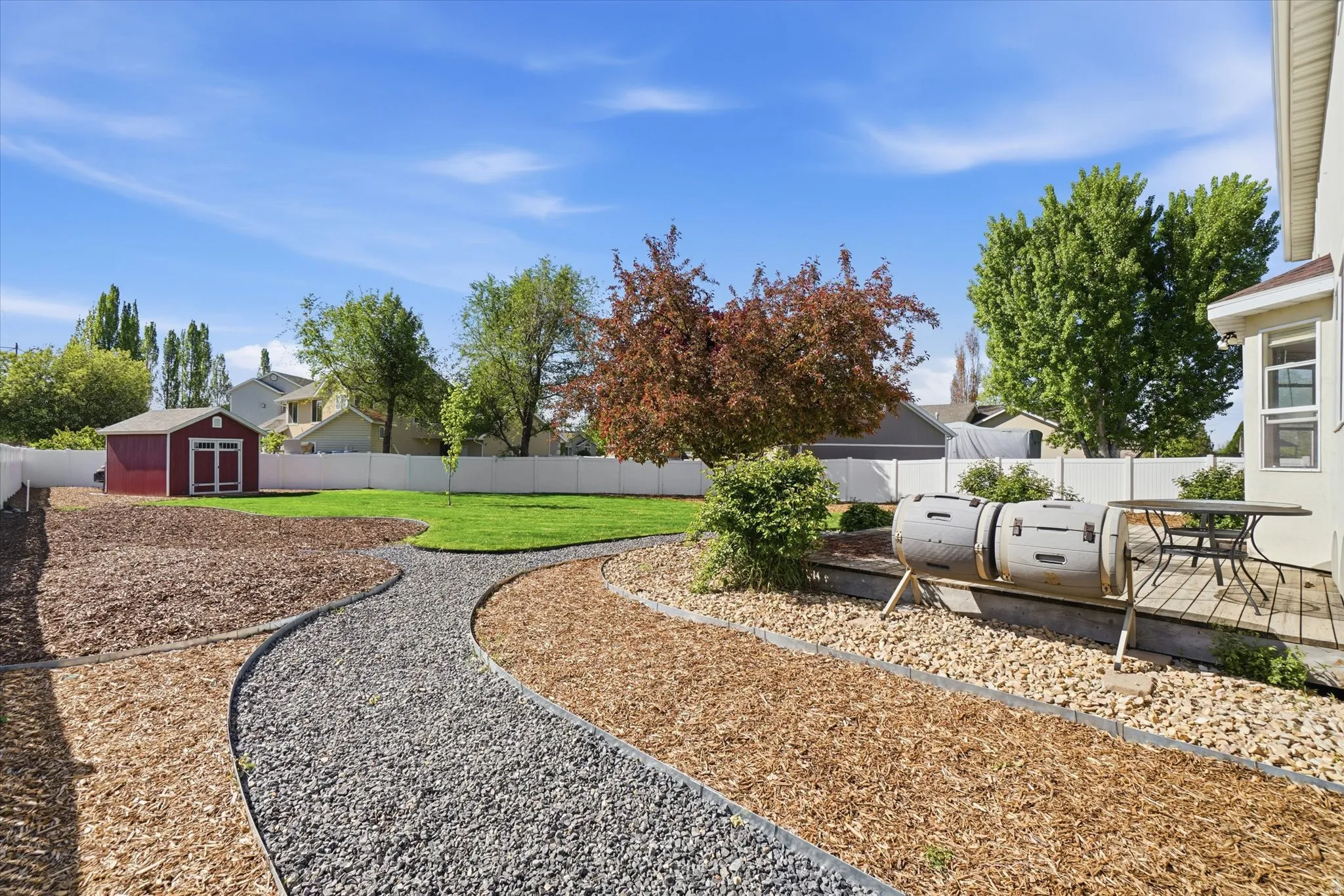 Fenced backyard featuring a storage shed