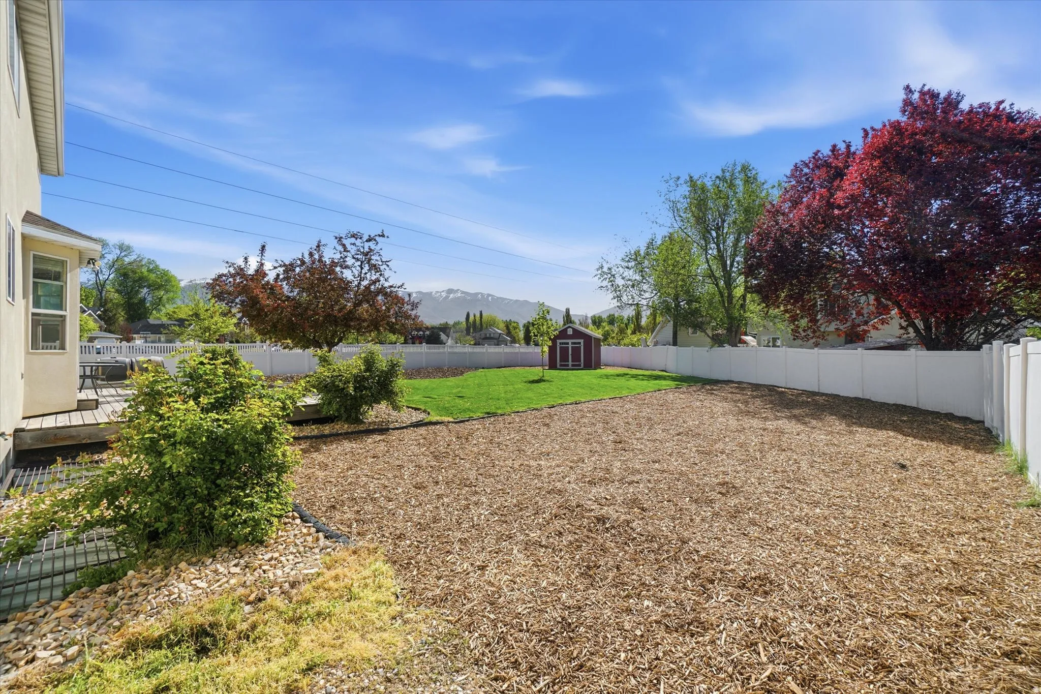 Fenced backyard with a storage unit and a mountain view