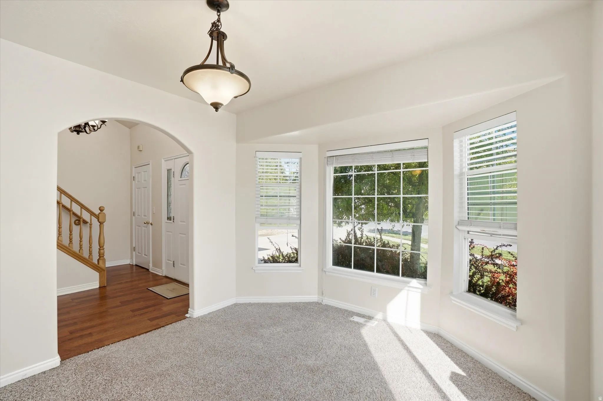 Spare room featuring arched walkways and carpet floors