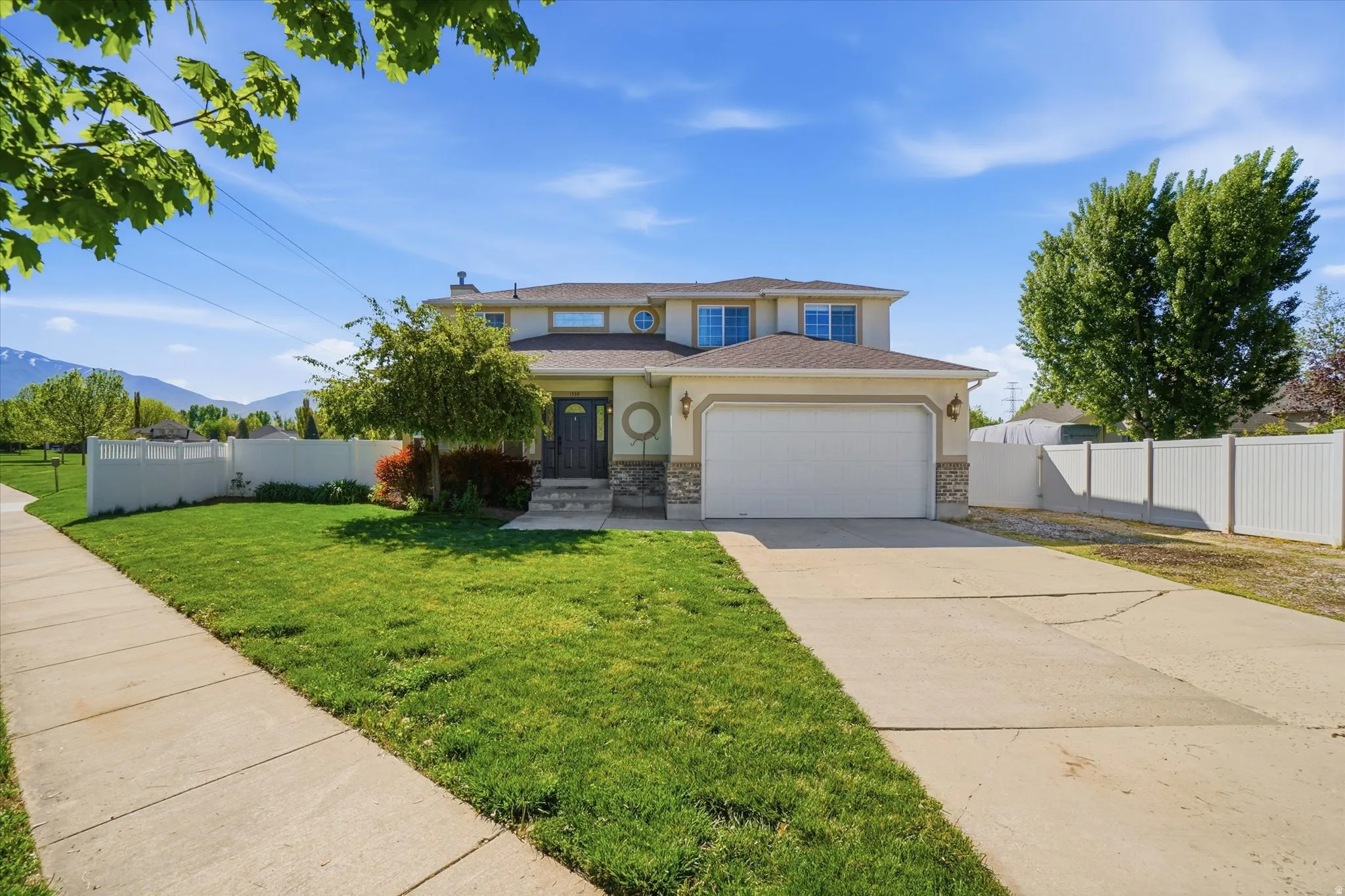 Traditional home with concrete driveway, a garage, a mountain view, and stucco siding
