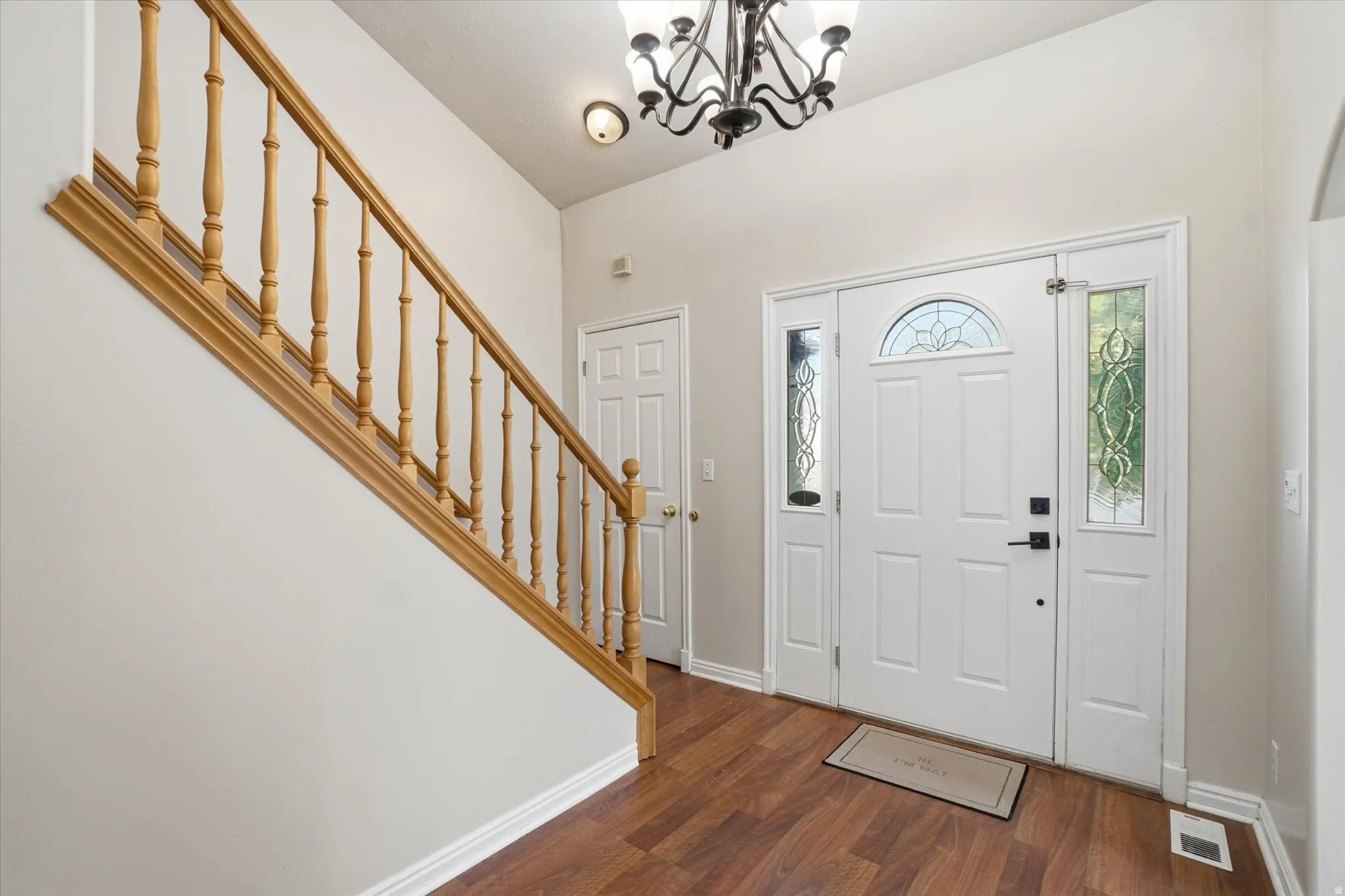 Entryway with dark wood finished floors and hanging lights