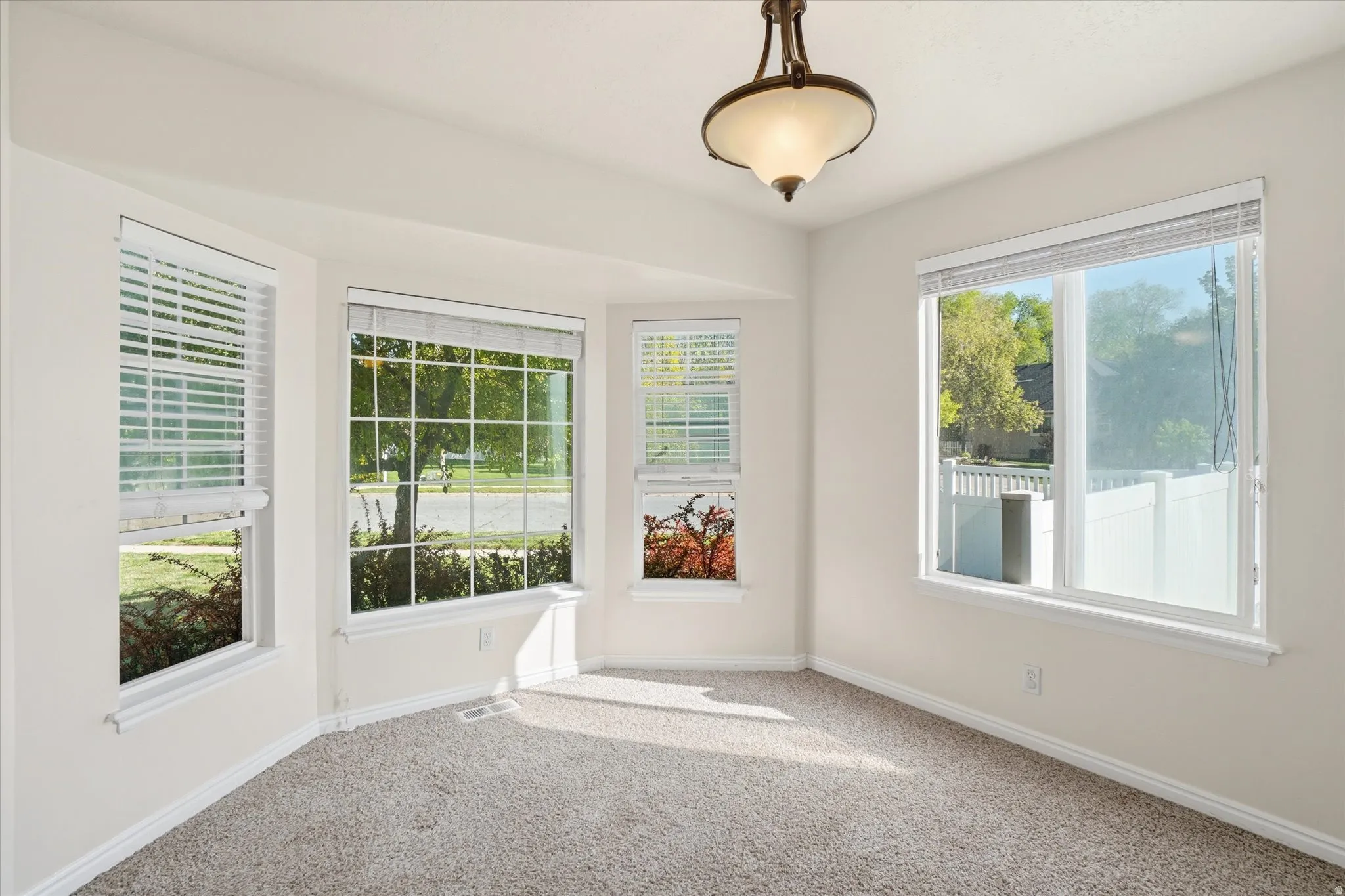 Empty room featuring light colored carpet and baseboards