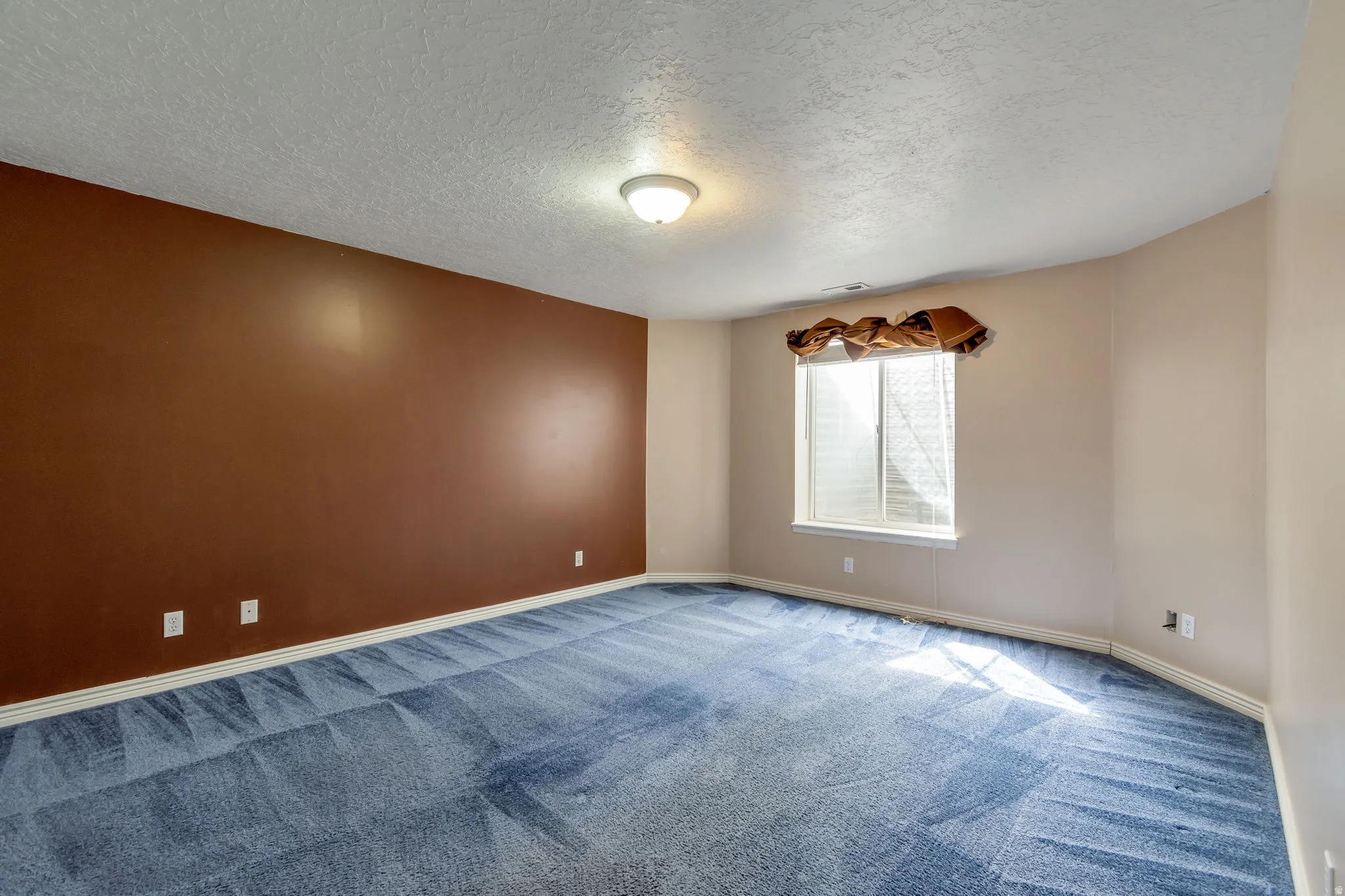 Unfurnished room with a textured ceiling and carpet floors