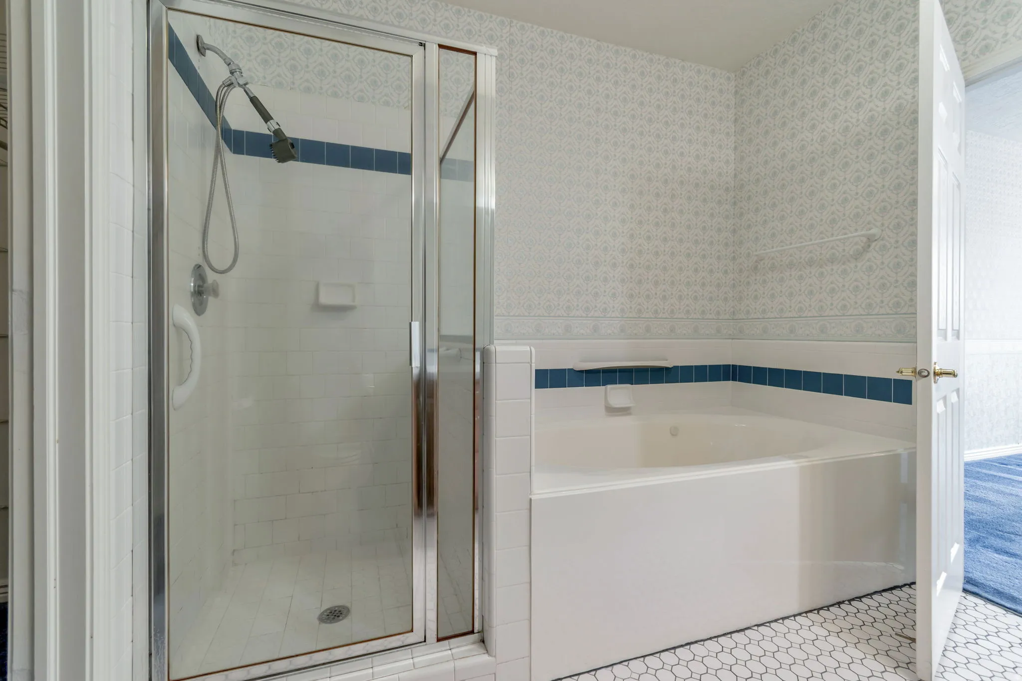 Full bathroom with wallpapered walls, a bath, a stall shower, and light tile patterned floors